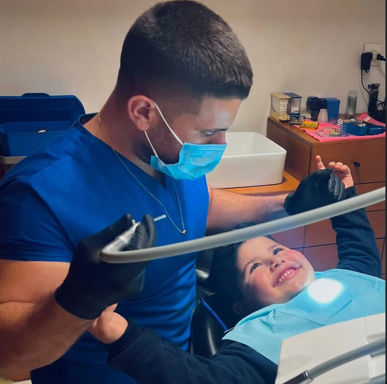 Dr. Abed Khabbaz reassuring a smiling young patient in the dental chair