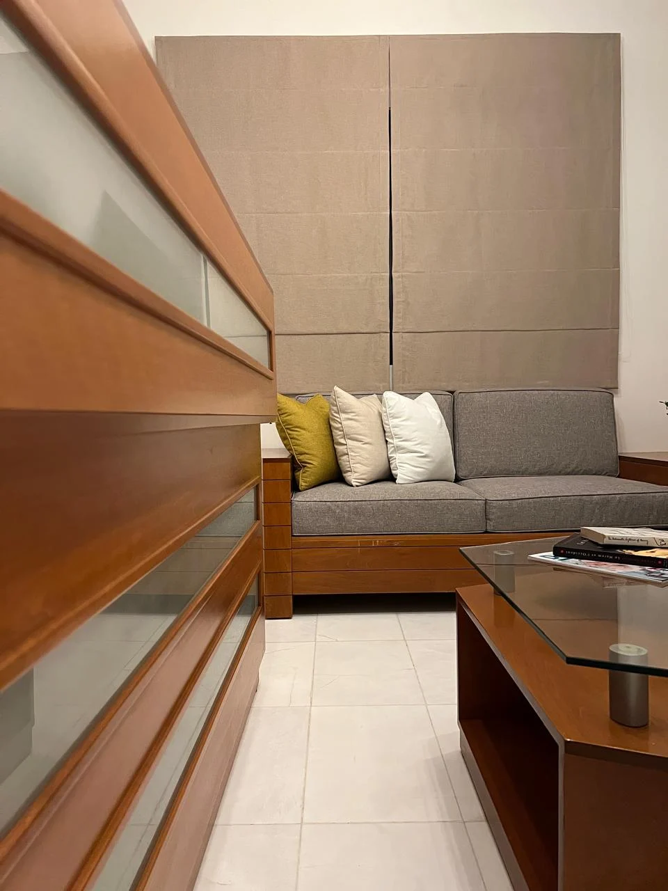 The clinic waiting area with a grey sofa and wooden furnishings